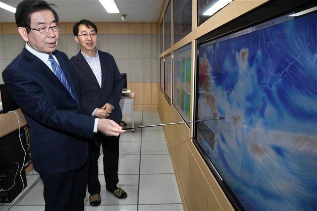 박원순(왼쪽) 서울시장이 지난해 4월 8일 서울시 보건환경연구원 대기질통합분석센터를 방문해 관계자로부터 대기질 모니터링 시스템에 대한 설명을 듣고 있다.서울시 제공