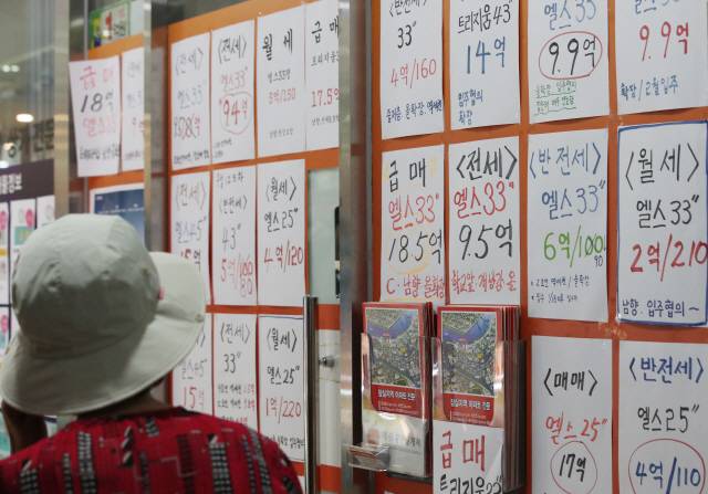 21일 토지거래허가구역으로 지정된 서울 송파구 잠실의 한 부동산 중개업소 앞에서 시민이 매물을 살펴보고 있다. /연합뉴스