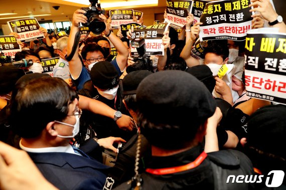 구본환 인천국제공항공사 사장이 22일 오후 인천공항1터미널에서 열린 기자회견에서 정규직 전환에 대한 입장을 밝히고 퇴장하자 '노동자 배제한 정규직 전환 즉각 중단하라'는 내용의 피켓을 든 노동조합원들이 항의를 하고 있다. 인천공항공사는 22일 인천공항 보안요원 1900여명을 정규직화 한다고 밝혔다.