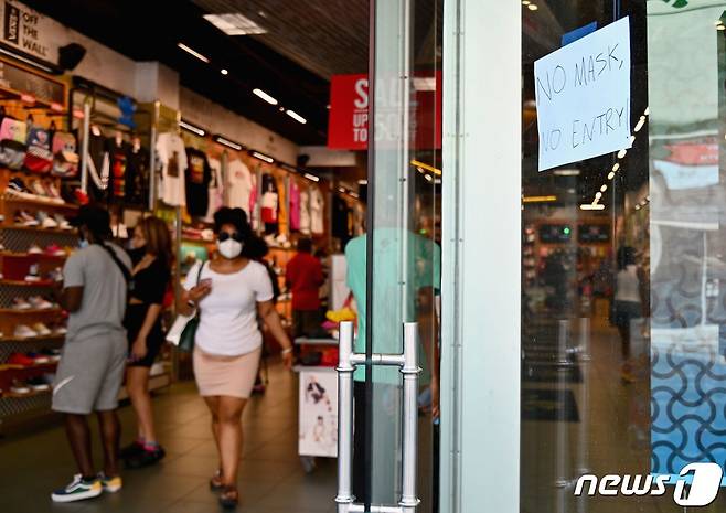 22일(현지시간) 뉴욕시에 있는 한 상점 문에 '마스크없이는 입장 불가'라는 글이 적혀 있다.© AFP=뉴스1