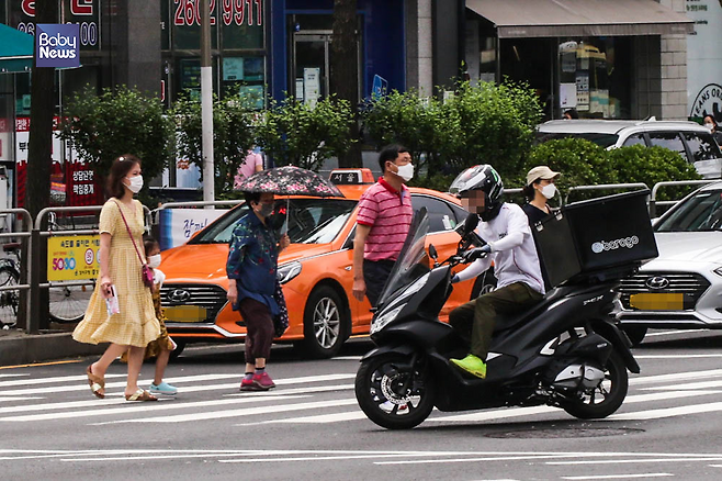 신호를 무시한 채 시민들 사이로 한 배달 오토바이가 가로질러 주행하고 있다. 김재호 기자 ⓒ베이비뉴스