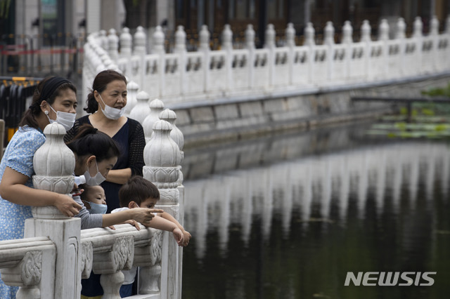 [베이징=AP/뉴시스] 25일 중국 베이징의 한 공원에서 관광객들이 마스크를 쓰고 호수를 둘러보고 있다. 2020.06.26