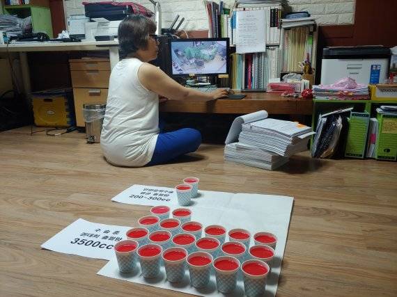 수술 중 권대희씨가 흘린 혈액 최소 추정치인 3500cc와 통상적인 안면윤곽수술 실혈량을 비교한 모습. 고 권대희씨 어머니 이나금씨가 지난 17일 권씨의 출혈 심각성을 시각적으로 보이기 위해 종이컵에 붉은 물감을 탄 물을 직접 담았다. 사진=김성호 기자