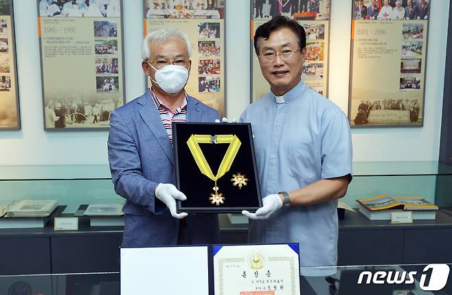 고 조비오 신부의 다섯째 동생인 조명현씨(72)가 고인을 대신해 수상한 국민훈장 모란장을 광주 남구 소화자매원 조영대 이사장에게 전달하고 있다. 조 신부의 모란장 훈장은 소화자매원 역사관에 영구 보관된다. 2020.6.28/뉴스1 © News1 박준배 기자