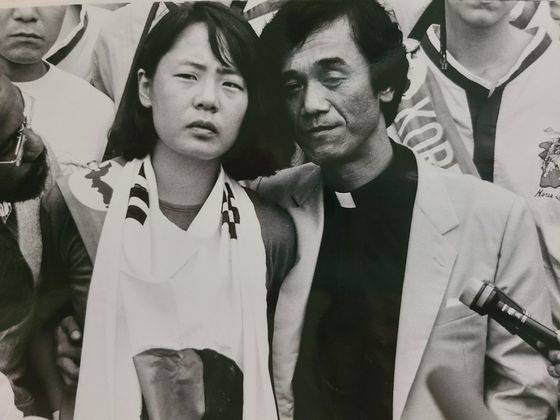 임수경은 방북 중에 평양에서 직접 만든 태극기를 목에 두르고 1989년 7월 27일 판문점을 통해 귀환을 시도했으나 실패했다. 결국 문규현 신부(오른쪽)와 함께 광복절인 8월 15일 오후 2시 22분 군사분계선을 걸어서 넘었다. 분단 이후 판문점을 통해 북에서 남으로 넘어온 최초의 민간인이 됐다. [사진 임수경]