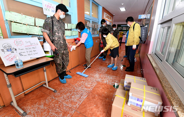 [광주=뉴시스] 신대희 기자 = 3일 광주 북구 운암동 모 초등학교에서 동 행정복지센터 직원들과 지역 예비군중대원들이 오는 6일 학생 등교를 앞두고 복도를 소독하고 있다. 2020.07.03. sdhdream@newsis.com