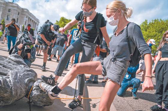 Americans stomp on a Christopher Columbus statue after it was toppled in front of the Minnesota State Capitol in St. Paul, June 10. [AP/YONHAP]