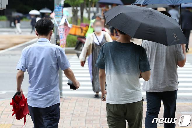 지난달 30일오후 서울 시내의 한 거리에서 시민들이 우산을 휴대하고, 쓰고 발걸음을 옮기고 있다. 2020.6.30/뉴스1 © News1 이승배 기자