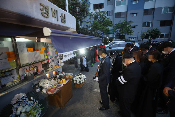 지난 5월 서울 강북구 우이동 한 아파트 경비실 앞에서 아파트 경비원으로 일하다 주민 괴롭힘에 최근 극단적 선택을 한  최희석 경비원의 유족들이 노제를 지내고 있다. 연합뉴스 제공.