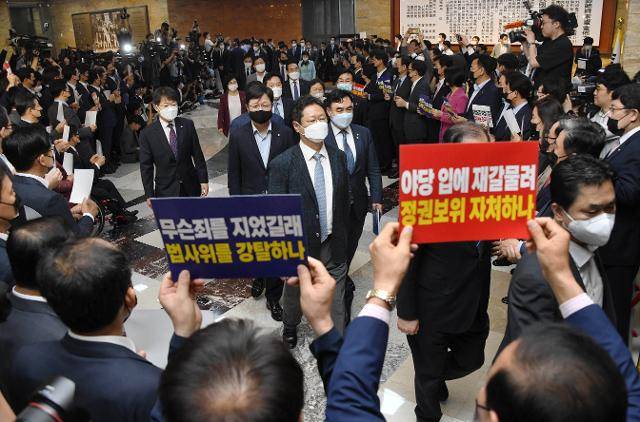 6월15일 국회 로텐더홀에서 피켓 시위를 벌이고 있는 미래통합당 의원들 사이로 더불어민주당 의원들이 ‘법사위원장’ 등 6개 상임위원장 선출을 위해 본회의장으로 입장하고 있다. 오대근 기자