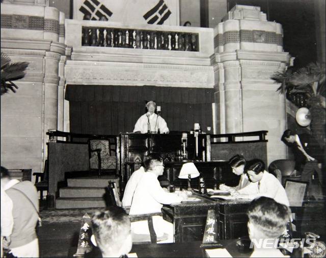 [서울=뉴시스] 1948년 7월 17일 오전 10시 중앙청 국회의사당에서 헌법에 서명한 후 이승만 국회의장은 “나 이승만은 국회 의장의 자격으로 이 간단한 예식으로서 서명하고 이 헌법이 우리 국민의 완전한 국법임을 세계에 선포합니다”라고 헌법 공포 했다. (사진=미국 국립문서기록청) 2020.07.12. photo@newsis.com (* 위 사진은 재배포, 재판매, DB 및 활용을 금지합니다)