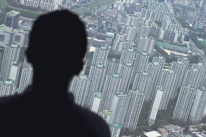 정부가 7.10 부동산대책을 발표하면서 다주택자에 대한 세금 부담을 크게 늘리자 반발하는 목소리가 크다. 한 시민이 서울 송파구 롯데월드타워에서 아파트 밀집지역을 바로보고 있다. [연합]