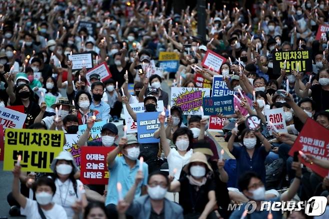 (서울=뉴스1) 이광호 기자(서울=뉴스1) 이광호 기자 = 정부의 고강도 부동산 규제에 반발하는 시민들이 25일 저녁 서울 중구 예금보험공사 앞에서 '부동산 규제정책 반대, 조세저항 촛불집회’를 하고 있다.2020.7.25/뉴스1   <저작권자 ⓒ 뉴스1코리아, 무단전재 및 재배포 금지>