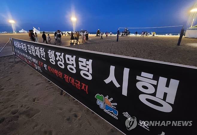 야간 취식행위 안됩니다 (속초=연합뉴스) 이종건 기자 = 강원 동해안 8개 주요 해수욕장에서 시행 예정인 야간 취식행위 단속을 앞두고 사전 계도 활동이 시작된 지난 18일 밤 속초해수욕장 입구에 집합제한 행정명령에 따른 단속 안내 현수막이 걸려있다.       2020.7.19 momo@yna.co.kr