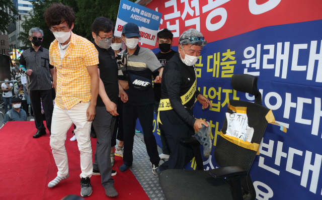 25일 오후 서울 중구 예금보험공사 앞에서 열린 ‘소급적용 남발하는 부동산 규제 정책 반대, 전국민 조세 저항운동 촛불집회’ 참가자들이 문재인 대통령 글자가 적힌 의자에 신발을 던지는 퍼포먼스를 하고 있다./연합뉴스