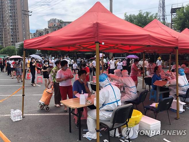 코로나19 환자 발생에 진료소로 몰린 중국 다롄 주민들 (다롄 AFP=연합뉴스) 최근 중국 랴오닝성 다롄시에서 신종 코로나바이러스 감염증(코로나19) 환자가 국지적으로 발생하고 있는 가운데 현지 주민들이 26일 주차장에 마련된 임시 진료소에서 줄지어 차례를 기다리고 있다. 당국은 이날 하루 신규 확진자가 61명으로 지난 4월 이후 가장 높은 수치를 기록했다고 밝혔다. jsmoon@yna.co.kr
