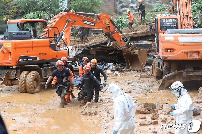 3일 경기도 가평군 가평읍 산유리의 한 펜션에 토사가 덮쳐 소방대원들이 구조작업을 벌이던 중 시신을 수습하고 있다. 2020.8.3/뉴스1 © News1 황기선 기자