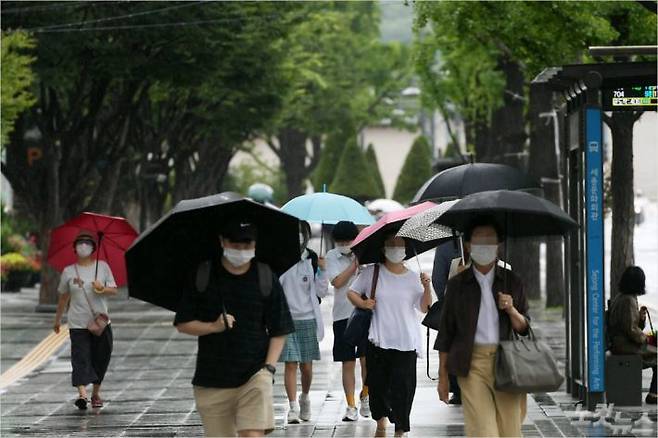 전국 곳곳 흐리고 비가 내리는 27일 오전 서울 광화문 인근에서 시민들이 우산을 쓰고 발걸음을 옮기고 있다. 이한형기자