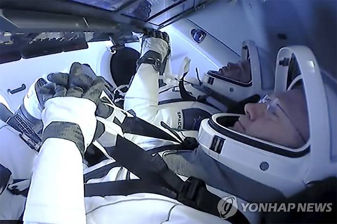 지구로 귀환 준비하는 NASA 우주비행사 (스페이스X AP=연합뉴스) 미국 항공우주국(NASA) 우주비행사 더그 헐리와 봅 벤켄이 2일(현지시간) 스페이스X 캡슐에서 지구로 귀환할 준비를 하고 있다. [NASA 제공] sungok@yna.co.kr