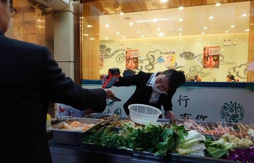 2019년 4월 중국 베이징의 길거리 음식 판매대에서 판매자가 고객 스마트폰의 QR코드를 스캔해 결제를 하고 있다. /베이징=김남희 특파원