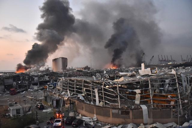 4일 레바논 베이루트 항구에서 일어난 대규모 폭발로 검은 연기와 화염이 치솟고 있는 가운데 폭발 현장 인근 건물이 폭격을 맞은 듯 부서져 있다. 베이루트=AFP 연합뉴스
