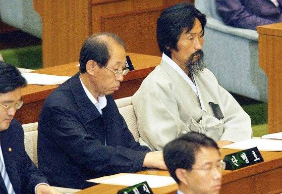 2004년 7월 두루마기를 입고 국회 본회의장에 앉아있는 강기갑 민주노동당 의원(우).