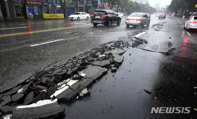 [광주=뉴시스] 류형근 기자 = 많은 비가 내린 7일 오후 2시께 광주 서구 상무중학교 앞 도로가 파손돼 차량 통행이 제한되고 있다. 2020.08.07. hgryu77@newsis.com