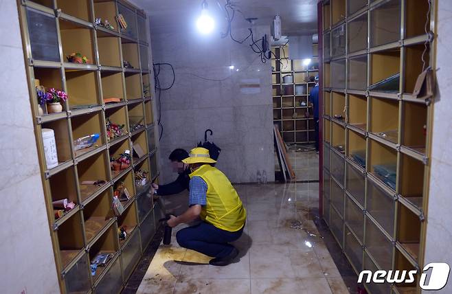 집중호우로 광주 영산강 인근에 있던 S추모관 내 유골함 1800여기가 침수피해를 당한 가운데 10일 한 유가족이 지하 1층에서 물에 젖은 유골함을 꺼내고 있다.2020.8.10 /뉴스1 © News1 박준배 기자
