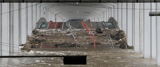 7일 집중호우로 통제 중인 잠수교가 물에 잠긴 가운데 상류에서 흘러온 쓰레기가 도로에 쌓여있다. 연합뉴스