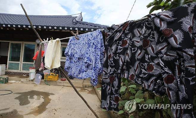 흙탕물을 씻어내기 위해 (남원=연합뉴스) 나보배 기자 = 폭우에 침수됐던 전북 남원시 금지면 상귀마을의 한 주택에 12일 오후 깨끗이 세탁된 옷이 빨랫줄에 널려 있다. 2020.8.12 warm@yna.co.kr