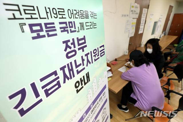 [서울=뉴시스] 이윤청 기자 = 정부 긴급재난지원금 현장접수 첫날인 18일 서울 송파구 삼전동 주민센터에서 시민들이 지원금 접수를 위해 신청서를 작성하고 있다.  2020.05.18. radiohead@newsis.com