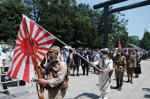 구 일본군 육군과 해군 군복을 입은 우익 단체 회원들이 15일 야스쿠니신사에서 욱일기를 들고 신사를 향해 받들어 총을 하고 있다. 도쿄=김청중 특파원 