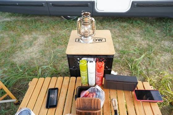 캠핑카 캠핑의 단촐한 짐. 테이블과 의자, 수납용 박스, 모기향, 램프면 충분하다. 윤경희 기자