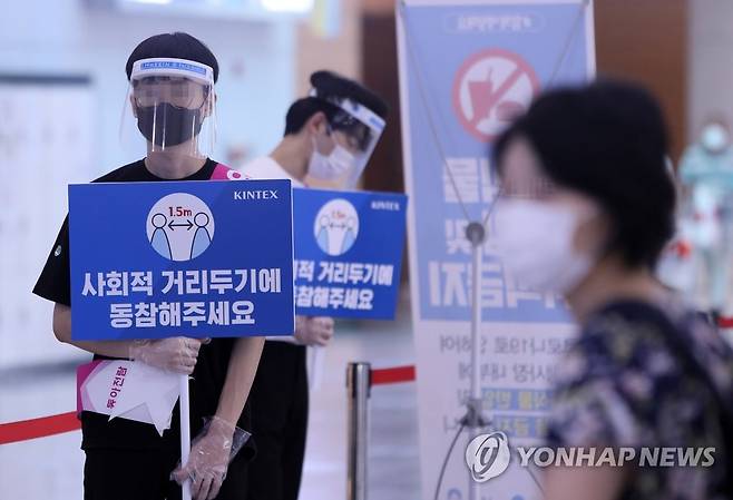'사회적 거리두기 동참해주세요' (고양=연합뉴스) 김병만 기자 = 20일 경기도 고양시 킨텍스 제1전시장에서 열린 제54회 MBC건축박람회에서 전시장 방역요원들이 '사회적 거리두기' 동참을 유도하고 있다. 이날 행사는 경기 고양시가 '집합금지 명령'을 시행해 취소됐으며 오는 30일까지 각종 전시와 관람 행사도 금지된다.  kimb01@yna.co.kr
