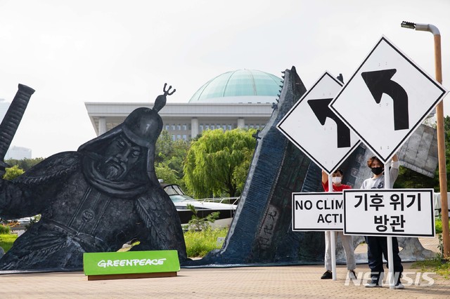[서울=뉴시스]국제환경단체 그린피스가 지난 20일 서울 여의도 한강공원 마리나 컨벤션 센터 앞 공터에서 서울의 주요 건물인 광화문, 남산서울타워, 이순신 장군 동상이 폭염으로 녹아내리는 가상 상황을 보여주는 퍼포먼스를 하고 있다. 그린피스는 올 여름 54일 동안 지속된 전례없는 장마와 폭우, 홍수 그리고 폭염 등 기후위기 재난이 현실화되었음을 정부에 상기시키고, 기후위기에 적극 대처할 것을 요구하기 위해 이번 퍼포먼스를 진행했다고 밝혔다. (사진=그린피스 제공) 2020.08.20. photo@newsis.com