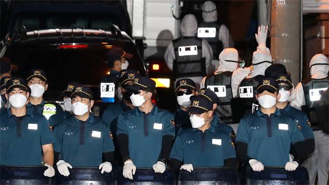 21일 오후 방역복을 입은 경찰관들이 압수수색을 위해 서울 성북구 사랑제일교회 내부로 들어가고 있을 때 다른 경찰관들이 진압 방패로 교인들의 진입을 막고 있다. 뉴시스