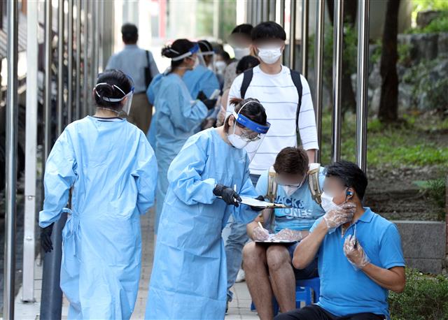 계속되는 코로나19 검사...분주한 의료진 - 25일 오전 서울 관악구보건소에 마련된 신종 코로나바이러스 감염증(코로나19) 선별진료소를 찾은 시민들이 검사를 기다리고 있다. 2020.8.25 뉴스1