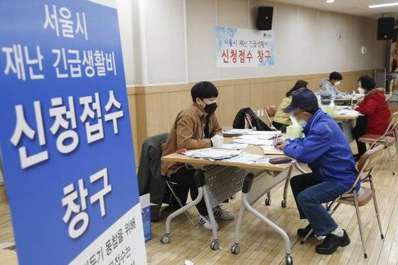 지난 4월 16일 오후 서울 성동구 왕십리도선동 주민센터에서 시민들이 서울시 재난긴급생활비를 오프라인으로 접수하고 있다. 1차 긴급생활비 지급 당시 결혼이민자ㆍ난민을 제외한 외국인은 대부분 지급 대상에서 빠졌다. 뉴시스.