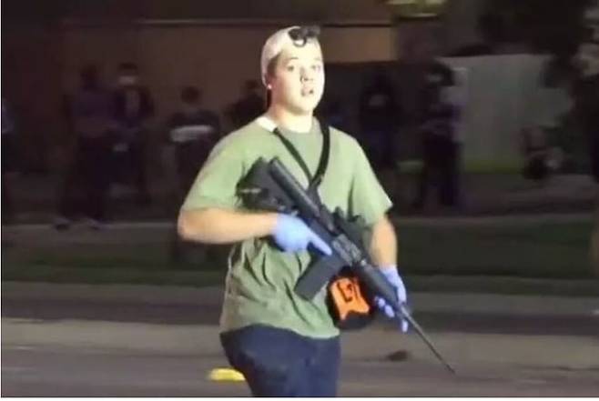 미국 위스콘신 커노샤에서 25일 밤(현지시각) 벌어진 시위에서 시위대를 향해 총격을 가한 청소년 카일 리튼하우스가 현장에서 총을 들고 ‘자경 활동’을 하고 있다. <시비에스 시카고> 화면 갈무리