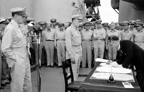 1945년 9월2일 일본 정부 대표(오른쪽)가 미국 군함 위에서 더글러스 맥아더 미군&nbsp;원수(왼쪽)가 지켜보는 가운데 무조건 항복 문서에 조인하는 모습. 세계일보 자료사진&nbsp;