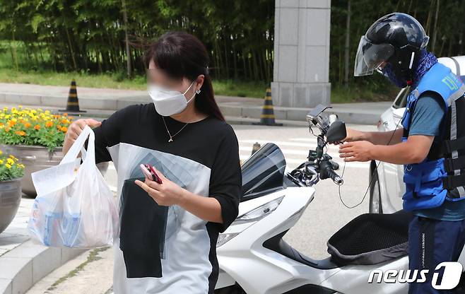 정부대전청사 공무원들이 31일 청사 출입구에서 배달음식을 받아가고 있다. 신종 코로나바이러스 감염증(코로나19) 확산으로 배달음식 및 도시락으로 점심을 해결하는 직장인이 늘어나고 있다 2020.8.31/뉴스1 © News1 김기태 기자