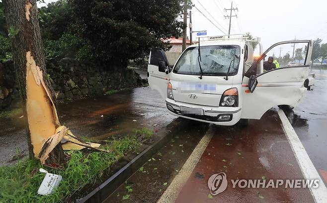 강풍에 교통사고도 발생 (서귀포=연합뉴스) 박지호 기자 = 제주가 북상하는 제9호 태풍 '마이삭'의 직접 영향권에 접어든 2일 오후 서귀포시 호근동의 한 도로에 강풍으로 인해 가로수를 들이받은 화물차가 견인을 기다리고 있다. 2020.9.2 jihopark@yna.co.kr