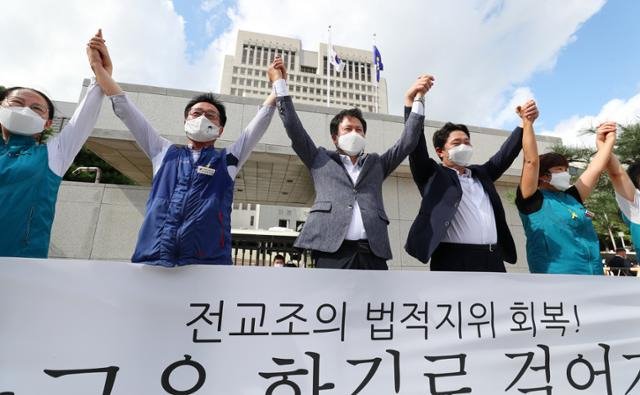 권정오(가운데) 전국교직원노동조합(전교조) 위원장을 비롯한 전교조 관계자들이 3일 오후 서울 서초구 대법원에서 열린 법외노조 통보처분 취소 소송 전원합의체 선고 공판에서 최종 승소한 뒤 기자회견을 열고 만세를 외치고 있다. 뉴스1