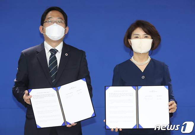 한정애 더불어민주당 정책위의장(오른쪽)과 최대집 대한의사협회장이 4일 오전 서울 여의도 민주당사에서 정책협약 이행 합의서에 서명한 후 기념촬영을 하고 있다. 민주당과 의협 간 합의안에는 의료계에서 파업 철회 조건으로 내걸어 온 "의대 정원 확대, 공공의대 신설 추진 등을 원점에서 재검토한다＂는 내용이 담겼다.2020.9.4/뉴스1 © News1 성동훈 기자