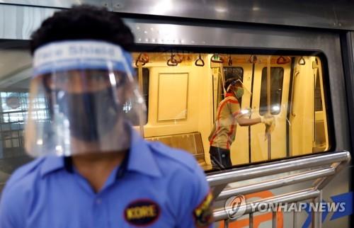 인도 수도 뉴델리에서 운행을 앞둔 지하철 차량을 소독하는 직원. [로이터=연합뉴스]
