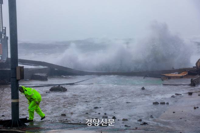 7일 제10호 태풍 ‘하이선’이 경북 포항 인근을 지나는 동안  한 경찰이 구룡포 해안 상가 주차장으로 파도가 넘어오자 시설 안전을 점검하고 있다.  2020.09.07 / 포항 | 이석우 기자