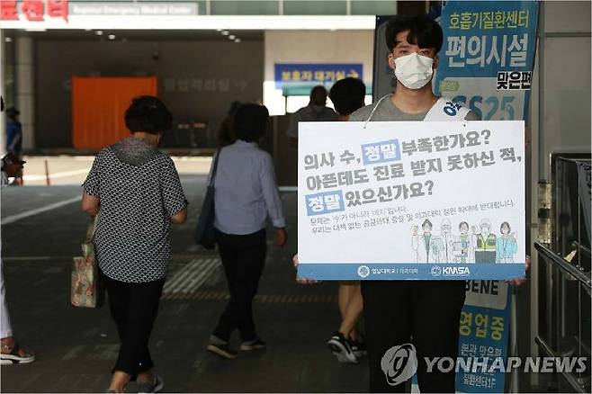 의과대학 정원 확대 정책 등에 반발해 대한의사협회가 2차 총파업에 들어간 지난 26일 대구 남구 영남대학교병원 본관 앞에서 한 의대생이 정부 정책에 반대하는 이유를 적은 피켓을 들고 있다. (사진=연합뉴스)
