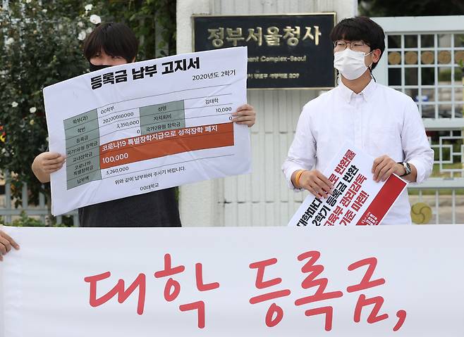 청년진보당 관계자들이 지난 10일 오전 정부서울청사 앞에서 열린 ‘코로나 시대 대학생 권리찾기 운동 선포 기자회견’에서 등록금 100만원 상한제 추진 등록금 반환에 대한 교육부의 관리·감독과 기준 마련을 촉구하며 구겨진 등록금 납부 고지서 패널을 들고 있다. [연합]