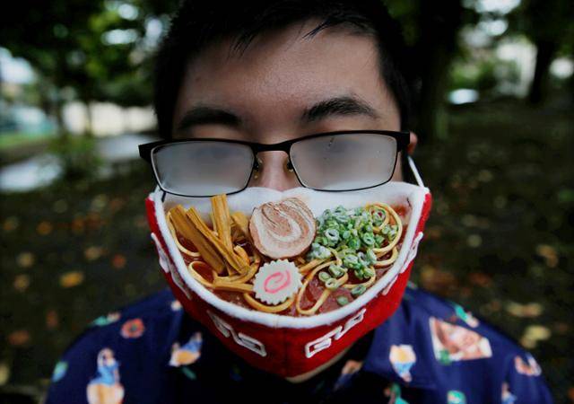 23일 일본 요코하마의 한 공원에 나온 디자이너 시바타 타카히로씨가 김이 모락모락 나는 라멘 그릇 같은 마스크를 쓰자 안경에 김이 서려 뿌렿게 흐려져 있다. 요코하마=로이터 연합뉴스