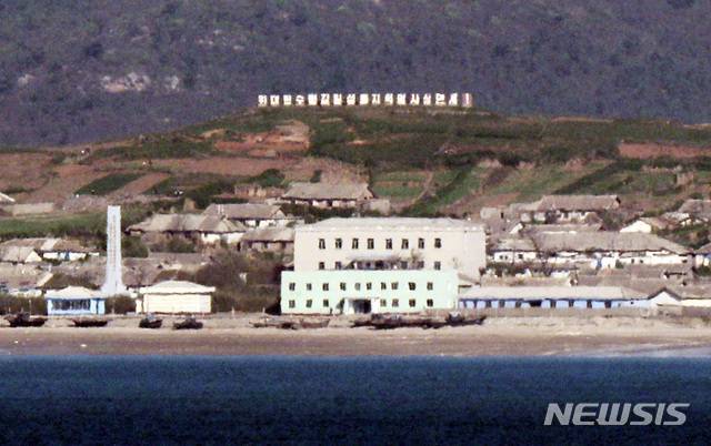 [연평도=뉴시스] 최진석 기자 = 26일 인천 옹진군 연평도에서 바라본 북한 옹진군 마을에 선전문구가 보이고 있다. 2020.09.26. myjs@newsis.com
